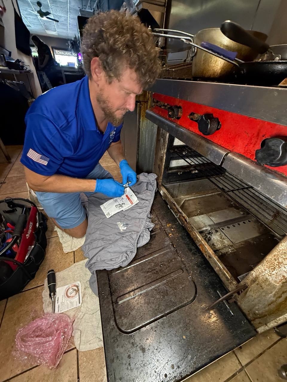 Technician servicing commercial kitchen equipment in Naples