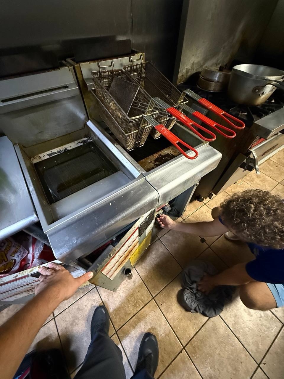 Technician inspecting commercial kitchen equipment in Naples